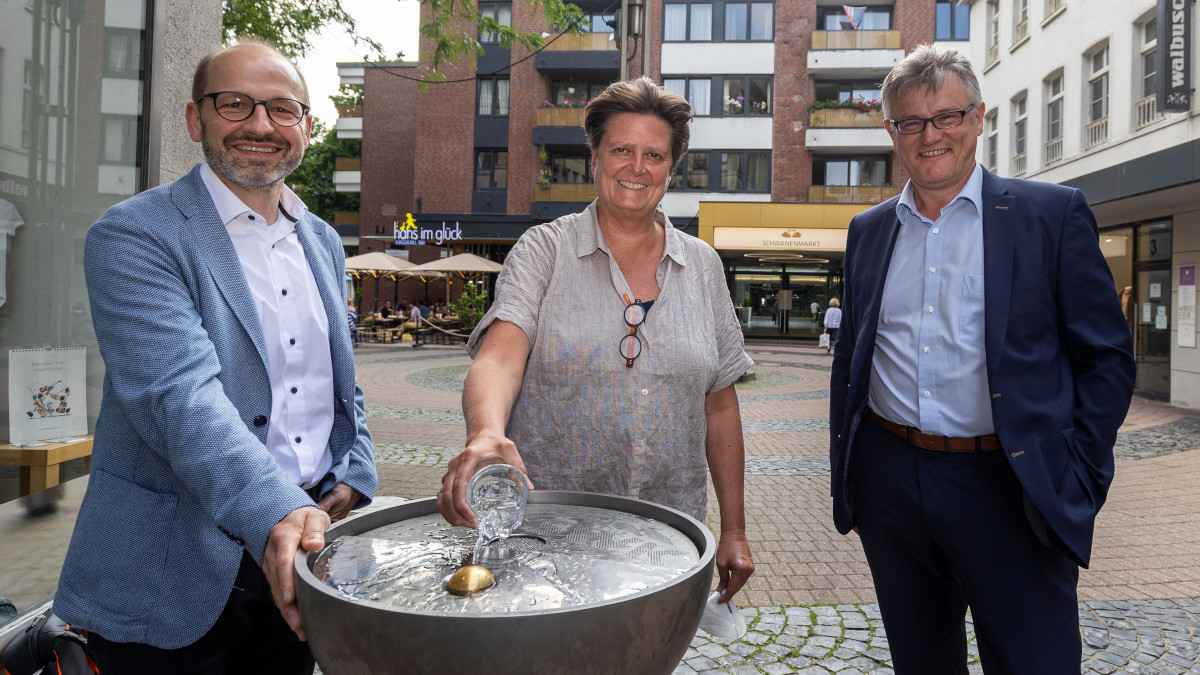Dirk Hagenräke, Sabine Lauxen und Christof Epe vor dem wieder in Betrieb genommenen Trinkwasserbrunnen am Schwanenmarkt.